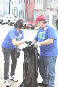 Marge Salazar, Associate Deputy Comptroller for Midsize Banks, and Hershel Lipow, Community Relations Expert, pick up debris on an Ivy City street.