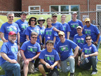 OCC volunteers take a break from cleaning up to gather outside the new Bexhill condominiums, which were developed by Manna, a NeighborWorks affiliate.